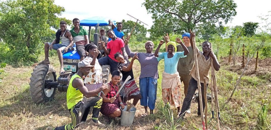 Eine Gruppe Menschen freut sich über gepflanzte Bäume in Ghana.